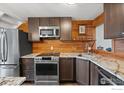 Modern kitchen features stainless steel appliances, granite countertops, and decorative wood backsplash at 2201 Pearl St # 321, Boulder, CO 80302