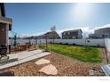 Private fenced backyard with a seating area and a well-maintained lawn at 2433 Tabor St, Berthoud, CO 80513