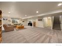 Spacious finished basement with a large seating area, neutral carpet, and a staircase at 2433 Tabor St, Berthoud, CO 80513