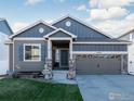 Charming home featuring neutral colors, a two-car garage, a well-maintained lawn, and beautiful landscaping at 2433 Tabor St, Berthoud, CO 80513
