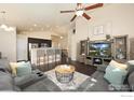 Open-concept living room with high ceilings, a ceiling fan, and a breakfast bar to the kitchen at 2433 Tabor St, Berthoud, CO 80513