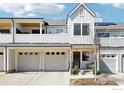 A townhome's façade with individual garages, a covered porch, and modern architectural design at 267 Clementina St, Louisville, CO 80027