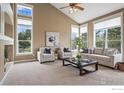 Cozy living room features vaulted ceiling, fireplace, and large windows at 3122 Notabon Ct, Lafayette, CO 80026