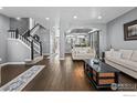 Spacious living room with hardwood floors and staircase leading to the second floor, creating a welcoming atmosphere at 338 Mt Wilson St, Brighton, CO 80601