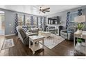 Cozy living room with a large sectional sofa, ceiling fan, and fireplace, perfect for relaxing and entertaining at 338 Mt Wilson St, Brighton, CO 80601