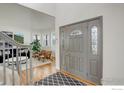Open entryway showcases stylish front door and adjoining living room with plenty of natural light and décor at 366 Blackhawk Ln, Lafayette, CO 80026