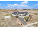 Aerial view of a white house, fenced yard, four-car garage, and long driveway at 3796 Vale View Ln, Mead, CO 80542