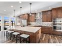 Spacious kitchen with custom cabinets, stainless appliances, quartz counters, and large island at 3796 Vale View Ln, Mead, CO 80542