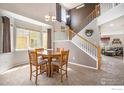 Open dining area with staircase, large windows, neutral walls, and modern light fixture at 4170 Combine Pl, Brighton, CO 80601
