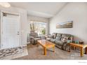 Comfortable living room featuring neutral tones, vaulted ceilings, and a large window for natural light at 4170 Combine Pl, Brighton, CO 80601
