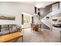 Open-concept living room with high ceilings, large windows, and a staircase to the second floor at 4170 Combine Pl, Brighton, CO 80601
