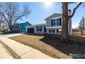 Inviting two-story house with a gray exterior, attached garage, and a mature tree in the yard at 4752 E 108Th Pl, Thornton, CO 80233