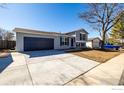 Attractive split-level home with a gray exterior, large driveway, and attached two-car garage at 4752 E 108Th Pl, Thornton, CO 80233