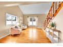 Cozy living room with hardwood floors, natural lighting, and a staircase at 4765 S Garland St, Littleton, CO 80123