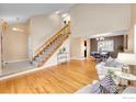 Spacious living room with hardwood floors, staircase, and an adjacent dining area at 4765 S Garland St, Littleton, CO 80123