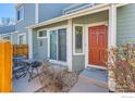 Close-up of a townhome entrance with a red door, small patio, and attractive number display at 5128 Buckingham Rd, Boulder, CO 80301