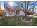 Lovely two-story home with a lush green lawn and mature tree in the front yard at 5894 Shenandoah Ave, Firestone, CO 80504