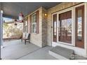 Inviting covered front porch with brick accents and a cozy bench at 5894 Shenandoah Ave, Firestone, CO 80504