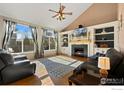 Bright living room featuring a fireplace, built-in shelves, and large windows at 5894 Shenandoah Ave, Firestone, CO 80504