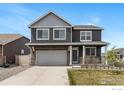 Inviting two-story home features a front porch, two-car garage and manicured lawn at 7231 Clarke Dr, Frederick, CO 80530