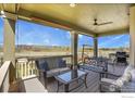 Relaxing outdoor seating area on a covered back porch, perfect for enjoying mountain views at 724 Dakota Ln, Erie, CO 80516
