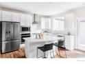 Bright kitchen features stainless steel appliances, a large island with bar seating, and white subway tile backsplash at 11488 E 25Th Dr, Aurora, CO 80010