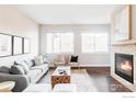 Bright living room features a cozy fireplace, modern decor, and ample natural light at 11488 E 25Th Dr, Aurora, CO 80010