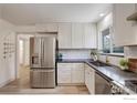 Well-lit kitchen featuring stainless steel appliances, white cabinets and dark countertops at 1496 Greenbriar Blvd, Boulder, CO 80305