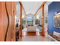 Inviting living room with high ceilings, wooden beams, a fireplace, and large windows overlooking the yard at 1533 Old Tale Rd, Boulder, CO 80303