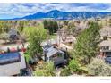 Stunning aerial view of a home with solar panels nestled amidst trees and mountain views at 2212 Juniper Ct, Boulder, CO 80304