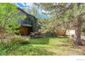 Beautiful backyard featuring a lush lawn, deck, and mature trees, perfect for outdoor relaxation at 2212 Juniper Ct, Boulder, CO 80304