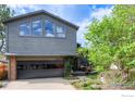Two-story home featuring a glass garage door, lush ivy, and a small patio area at 2212 Juniper Ct, Boulder, CO 80304