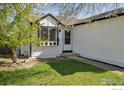 Well maintained yard features a lovely tree, side entrance, and lush grass at 2476 Sunset Dr, Longmont, CO 80501