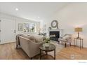 Bright living room with a fireplace, wood floors, and ample natural light at 2476 Sunset Dr, Longmont, CO 80501
