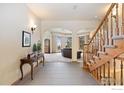 Welcoming foyer featuring tile flooring, an elegant staircase, and arched doorways to living spaces at 24771 Westridge Rd, Golden, CO 80403