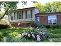 Lovely home featuring blooming flowerbeds and a well-maintained lawn under mature shade trees at 308 Baron Ave, Lafayette, CO 80026