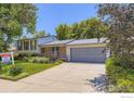 Street view of a home showing the front exterior, driveway, and well-maintained landscaping at 308 Baron Ave, Lafayette, CO 80026