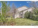 Landscaped yard surrounds this home with a manicured lawn and mature flowering bushes at 348 Eisenhower Dr, Louisville, CO 80027