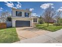 Charming two-story home with a spacious driveway and well-manicured lawn on a sunny day at 348 Eisenhower Dr, Louisville, CO 80027