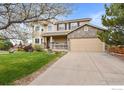 Charming two-story home featuring a stone accent garage, covered porch, and well-maintained lawn at 4833 Falcon Dr, Frederick, CO 80504