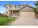 Charming two-story home featuring a stone accent garage, covered porch, and well-maintained lawn at 4833 Falcon Dr, Frederick, CO 80504