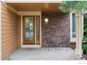 Inviting front porch featuring a decorative glass door, brick wall, and seating for relaxing outdoors at 5285 Gallatin Pl, Boulder, CO 80303