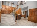 Grand foyer features a staircase, wood paneling and chandelier at 5442 S Dayton Ct, Greenwood Village, CO 80111