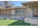Close up of brick home showcasing attached garage, wooden fence, and front yard at 7136 S Newland St, Littleton, CO 80128