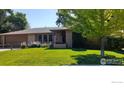 Well maintained single story brick home with lush green lawn and mature shade trees at 7136 S Newland St, Littleton, CO 80128