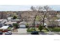 An aerial view shows the home with a driveway, garage, and mature trees in a suburban setting at 720 Bunyan Ave, Berthoud, CO 80513