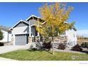 Attractive home with gray siding, stone accents, a two-car garage, and mature landscaping at 790 Lowrey Ln, Berthoud, CO 80513
