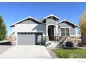 Inviting home with gray siding, stone accents, an American flag, and a well-maintained front lawn at 790 Lowrey Ln, Berthoud, CO 80513