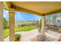 Covered patio featuring plenty of space for dining and entertaining overlooking the backyard at 82 Rivera Ct, Erie, CO 80516