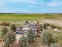 Expansive property featuring a home with solar panels, three car garage and views of greenery and fields at 8924 Prairie Knoll Dr, Longmont, CO 80503